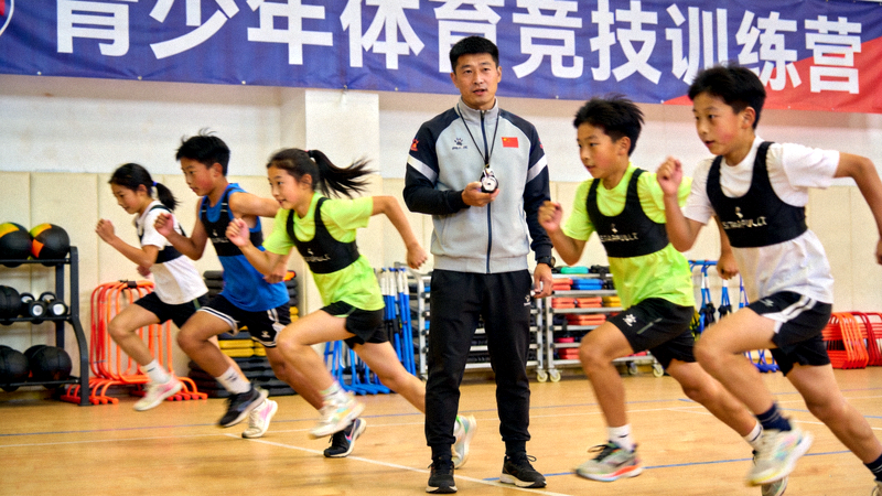 青少年体育竞技训练营中教练正在指导年轻选手训练