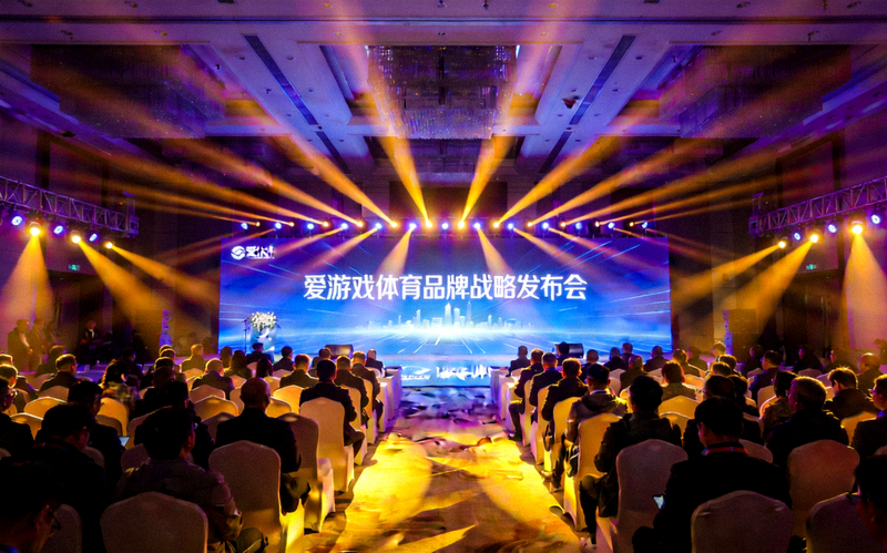 爱游戏体育品牌战略发布会现场，观众席与舞台灯光交相辉映